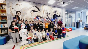 Dzieci stoją na ściance z flagami Unii Europejskiej –