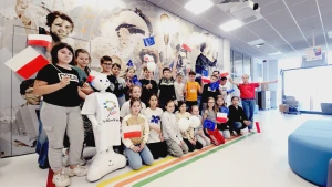 Dzieci stoją na ściance z flagami Unii Europejskiej –