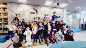 Dzieci stoją na ściance z flagami Unii Europejskiej –