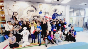 Dzieci stoją na ściance z flagami Unii Europejskiej –