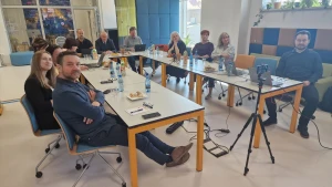 Członkowie Stowarzyszenia siedzą przy stołach słuchając prezentacji – 