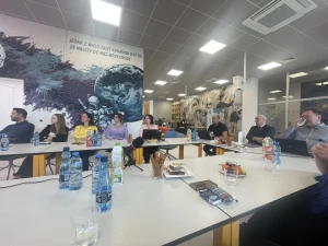 Członkowie Stowarzyszenia siedzą przy stołach słuchając prezentacji – 