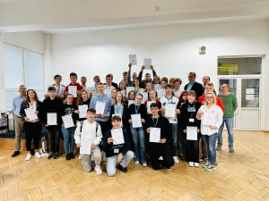 Uczniowie biorący udział w projekcie pozują do zdjęcia z certyfikatami zakończenia warsztatów –