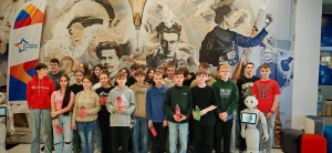 Uczniowie stoją na tle ścianki ze słynnymi wynalazcami i twórcami postępu – 